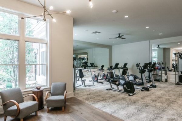Different Angle Of The Gym In Harpeth Square Apartments. It Has Multiple Set Of Weights, TVs, Elliptical Machines, Chairs And Other Appliances.