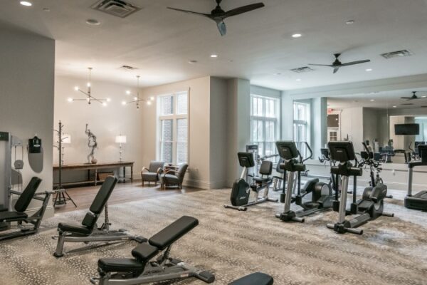 Different Angle Of The Gym In Harpeth Square Apartments. It Has Multiple Set Of Weights, TVs, Elliptical Machines And Other Appliances.