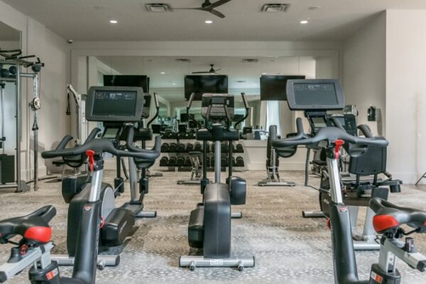 Different Angle Of The Gym In Harpeth Square Apartments. It Has Multiple Set Of Weights, TVs, Elliptical Machines.