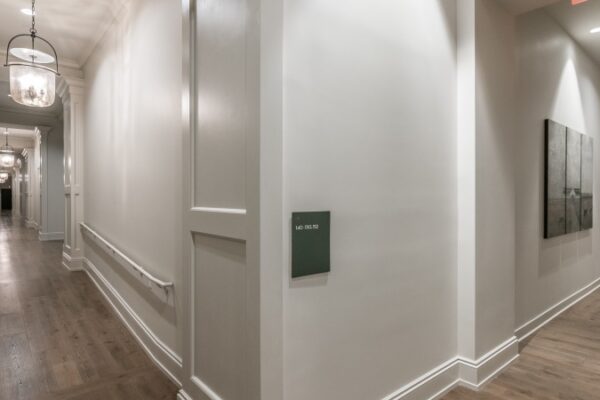 Different Angle Of The Hallway In Harpeth Square Apartments. White Walls, Lights, And Looks Clean And Elegant.