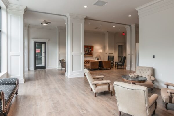 Lobby Area At The Entrance Of Harpeth Square, It Has Multiple Chairs And Coffee Tables In A Big Space.